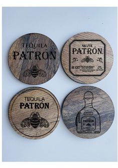 four coasters with different types of liquor bottles on the front and back, all engraved in black ink