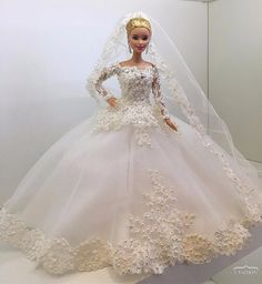 a barbie doll wearing a white wedding dress and veil with flowers on it's skirt