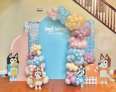 an arch made out of balloons with cartoon characters on the front and back sides, along with other decorations