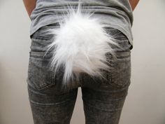 the back of a woman's jeans with a white feather on it