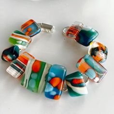 a multicolored glass bead bracelet on a white surface