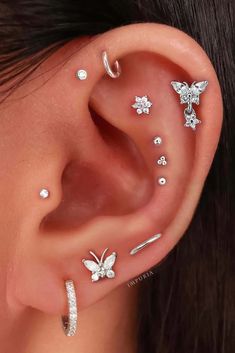 a woman's ear with four different piercings