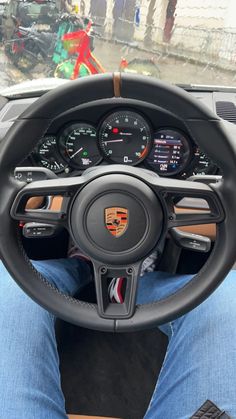 the interior of a car with steering wheel and gauges