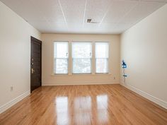 an empty room with hard wood floors and white walls