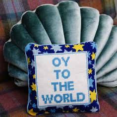 a cushion with the words oy to the world on it sitting on a couch