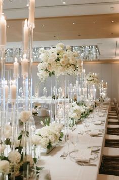 a long table with white flowers and candles