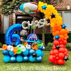 an arch made out of balloons in front of a house with the words chase on it