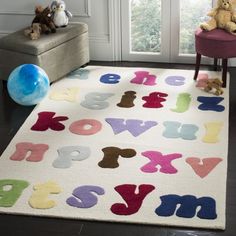 a child's rug with letters and numbers on it in front of a window