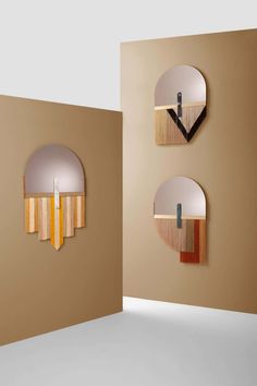 three circular mirrors mounted to the side of a wall next to each other on a beige wall