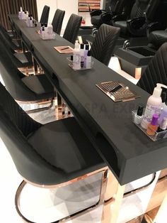 a long table with black chairs and bottles on it