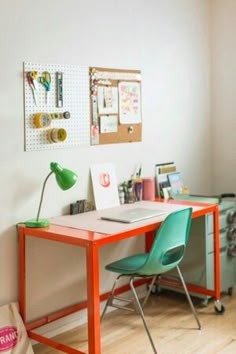 a desk with two green chairs next to a wall mounted bulletin board and pegboard