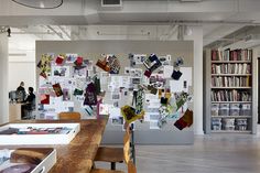 an office with many bookshelves and pictures hanging on the wall, along with wooden chairs