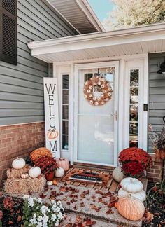 a front door decorated for fall with pumpkins and gourds