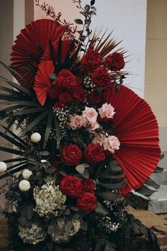 a bouquet of flowers and red umbrellas on a table in front of a building