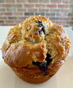 a blueberry muffin sitting on top of a white plate