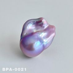 a close up of a purple pearl on a white surface