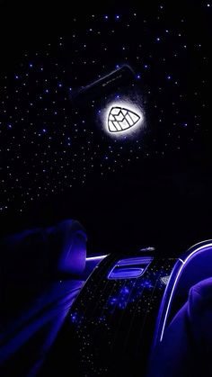 the interior of a car is lit up with blue lights and stars in the night sky