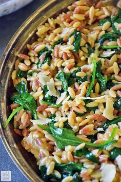 a bowl filled with rice and spinach on top of a table