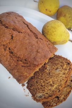 a loaf of bread sitting on top of a white plate next to two pears