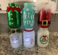 three mason jars with christmas decorations on them