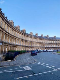 a curved building with cars parked on the street