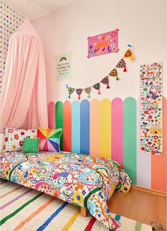 a colorful bedroom with a bed, rugs and hanging decorations on the wall above it