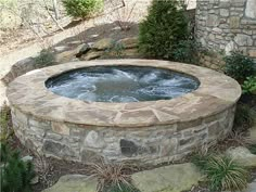 an outdoor hot tub surrounded by stone steps