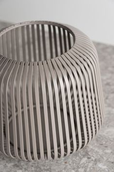 a close up of a metal object on a table with marble flooring and walls in the background