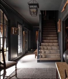 a staircase leading up to the second floor in an old - fashioned house with black walls and wood trim