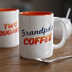 two coffee mugs sitting on top of a wooden table