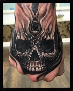 a hand with a skull tattoo on it