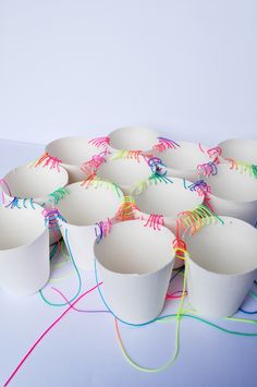 many white cups with colored string in them