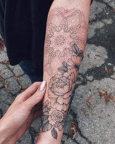 a person with a tattoo on their arm holding onto another person's arm and hand