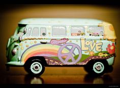 a toy bus with peace signs painted on it's side and the word love