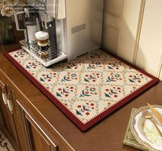 a coffee machine sitting on top of a kitchen counter next to a plate and knife