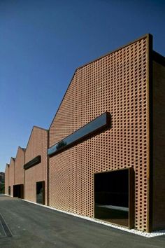 a brick building with three garages on the side and one door open to let in light