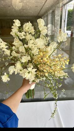 a person holding a bouquet of white flowers