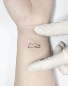 a person with a small tattoo on their left arm and the other hand behind them