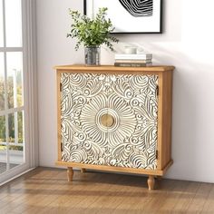 a wooden cabinet with an intricate design on the front and side panels, along with a potted plant