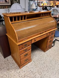 an old fashioned wooden desk with drawers on the top and bottom, in a store