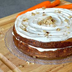 a carrot cake with frosting on a wooden cutting board