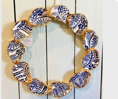 a blue and white wreath hanging on the side of a wooden wall