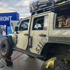 a jeep is parked in front of a blue sign