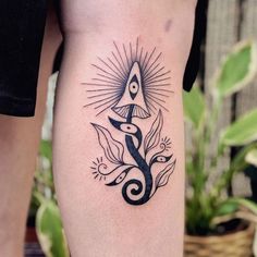 a black and white tattoo on the leg of a woman's lower body, with an all seeing triangle in the center