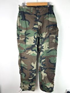 Rare pair of 1980s vintage' suit chemical protective class 1 trousers'  from US army. These are in a classic woodland camo with a wide baggy cut leg, more pockets then a standard trouser and zipper cuffs.  Feels to be a heavy cotton - Imagine its a poly style blend, no fabric content. Lined inside with a black satin like fabric Tagged size Small Measure  18.5'' across waist, tighten to 14.5'' across - Best suited around a 32'' waist, with some allowance for adjustment  13'' front rise  22.5'' se Full Length Camouflage Cotton Cargo Pants, Camouflage Cotton Full-length Cargo Pants, Military Style Camouflage Straight Leg Parachute Pants, Camouflage Military Style Parachute Pants, Casual Cotton Hunting Pants, Military Cargo Pants With Pockets For Hunting, Baggy Military Cargo Pants, Military Style Hunting Bottoms With Pockets, Military Hunting Bottoms With Pockets