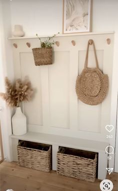 a white bench with baskets hanging on it