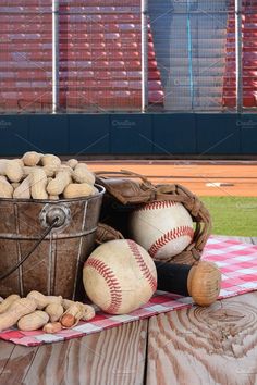 baseballs and nuts are sitting in a bucket on a picnic table