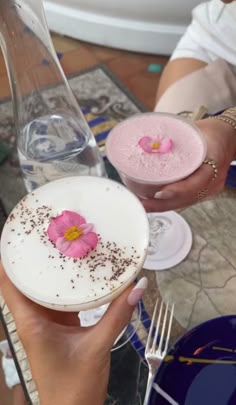 two people holding plates with desserts on them, one is pink and the other is white