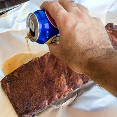 a man is holding a can of soda and some food