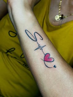 a woman's arm with a heart and heartbeat tattoo on her left arm, which reads love